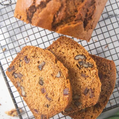 An overhead shot of slices of date and nut bread on a cooling rack.