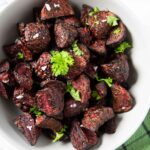 An overhead shot of a plate of air fryer beets, garnished with sea salt and parsley.