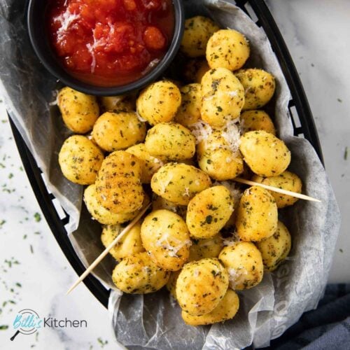 Feature image for crispy air fryer gnocchi, highlighting the dried herbs and grated cheese.