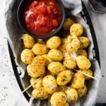 An overhead shot of crispy gnocchi served as an appetizer with dipping sauce.