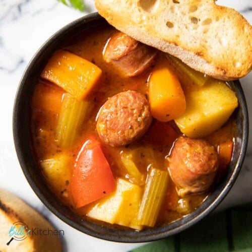 Feature image for Italian Sausage with Vegetables, showing the dish in a bowl with some crunchy bread.