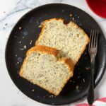 An overhead shot of two slices of poppy seed cake, served with coffee.