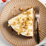 Feature image for Olive Oil Carrot Cake, showing a slice of it on a plate, with crushed walnuts on top.