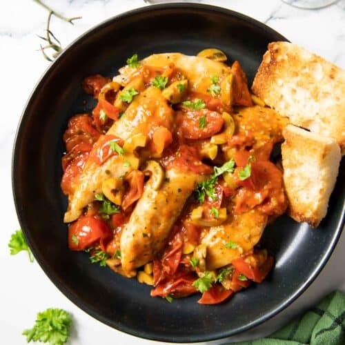 Feature image for one pan chicken with cherry tomatoes, served with some toasted bread.