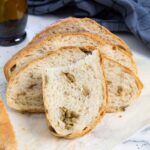 Feature image for Green Olive Loaf Bread showing green olives inside the soft bread.
