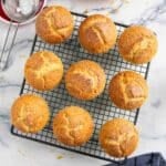 Freshly baked orange yogurt muffins with oil, cooling on a rack.