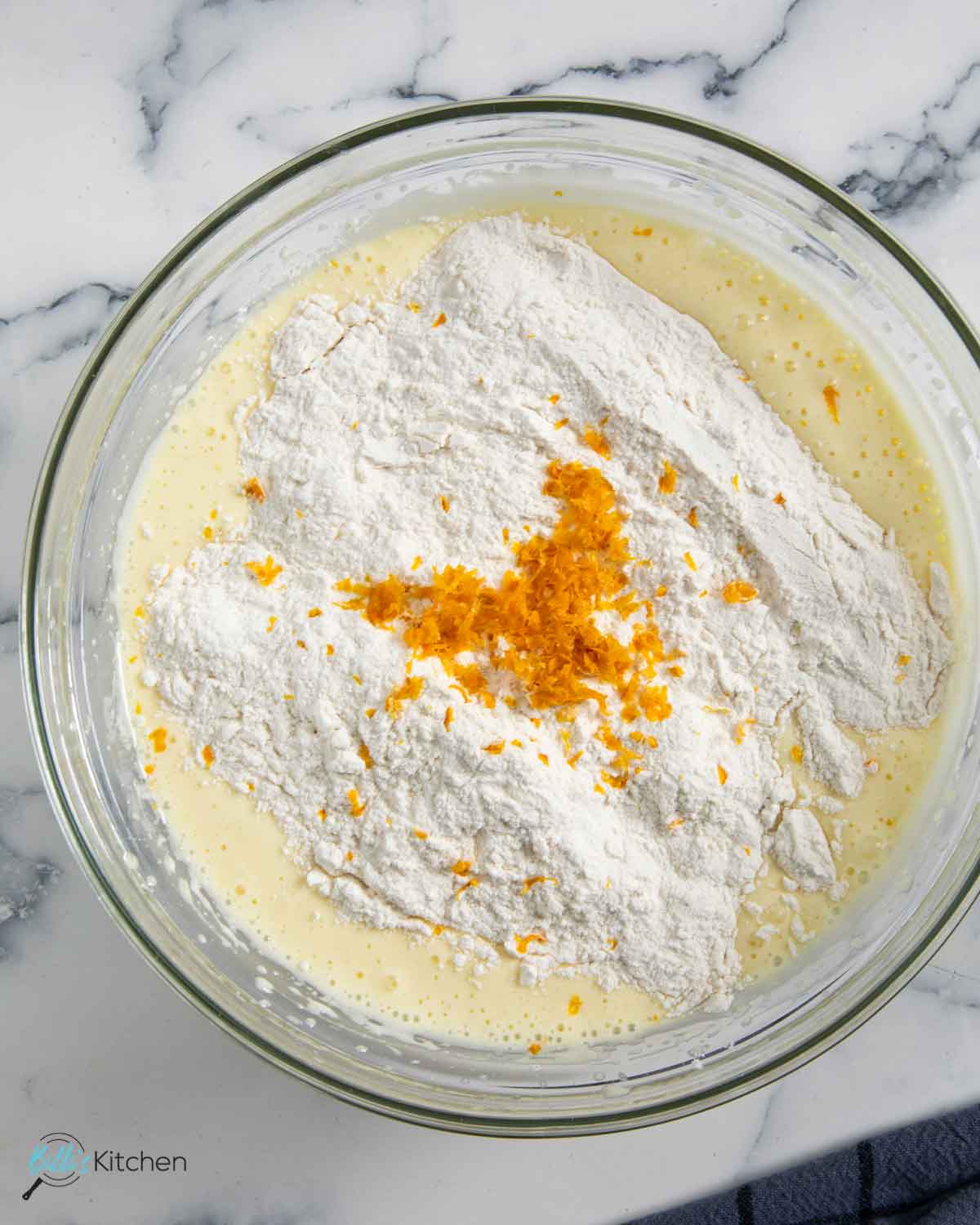 Combining the flour and orange zest with the ingredients for orange muffins with yogurt and oil.