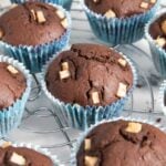 A closer shot of chocolate pear muffins cooling on a rack, highlighting the top of the muffins.