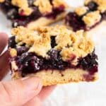 Lemon blueberry squares with one piece showing the crust, topping and crumb.