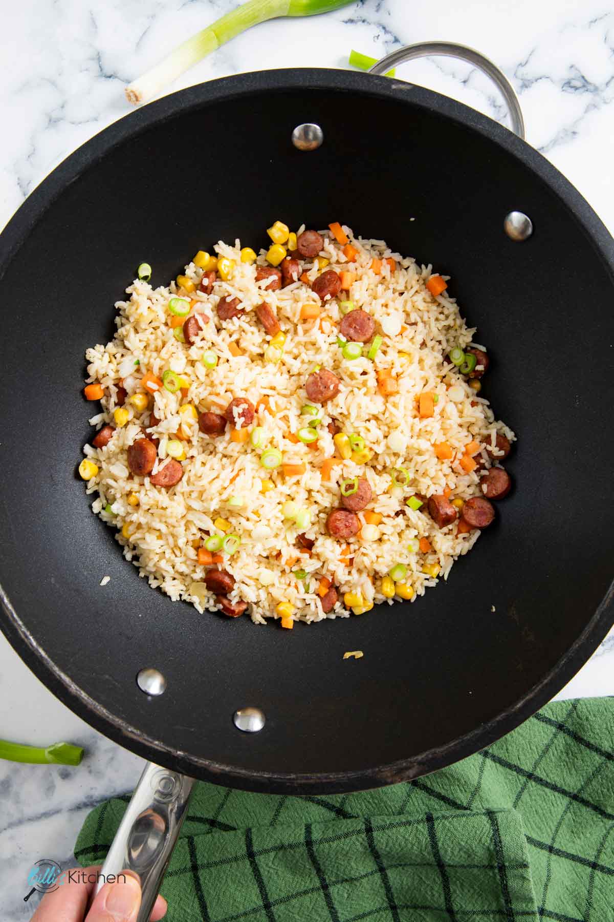 A wok straight out of the heat, ready for serving fried rice with kielbasa.