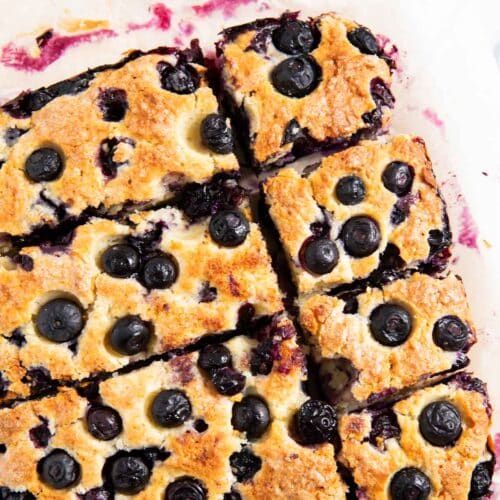 A closer shot of slices of yogurt breakfast cake with blueberries highlighting the golden color of the cake.