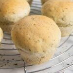 A closer of a piece of herb bread roll, highlghting its golden color.