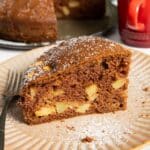 A slice of chocolate apple cake, highlighting its texture and the bits of fruit in it.