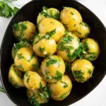 Boiled potatoes with parsley and butter, served as a side dish.