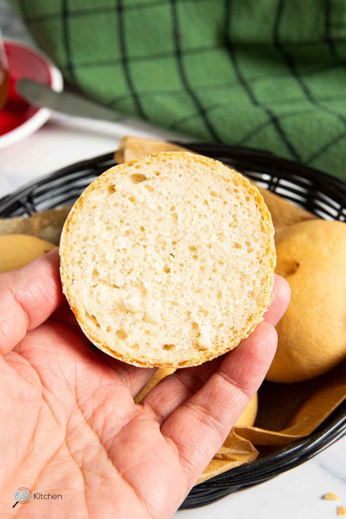 Holding a half-sliced yogurt bun to show its soft texture.