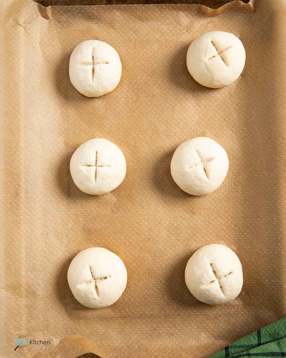 Yogurt buns ready for its second proofing, with the cross marks just created on top.