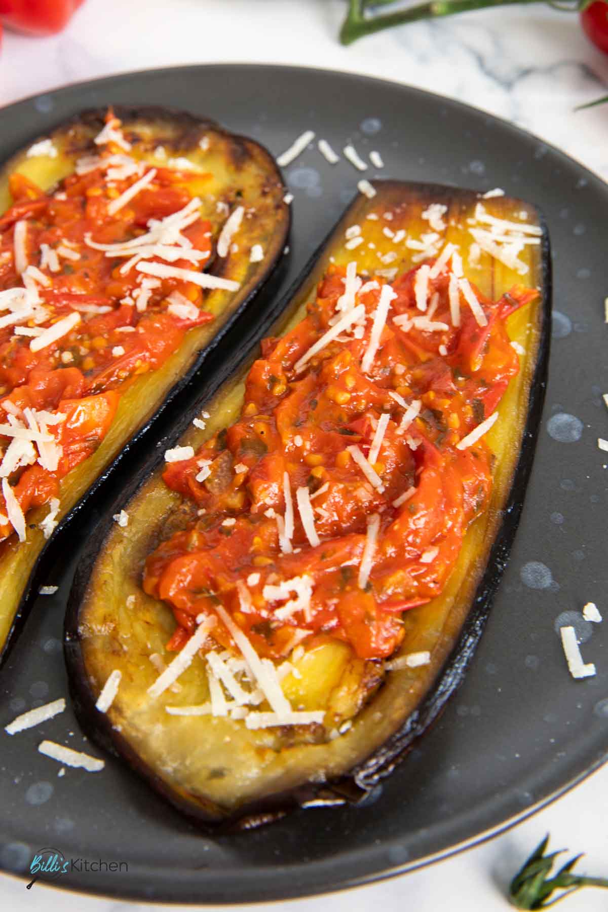 A closer shot of roasted eggplant with tomatoes, highlighting the soft texture of the eggplants.