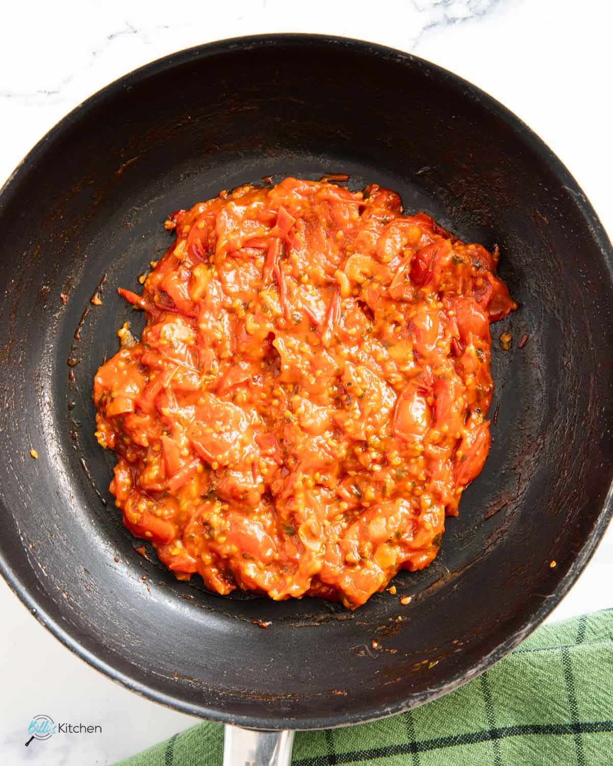 Thickened fresh tomatoes to be added to the eggplants roasted in the oven.