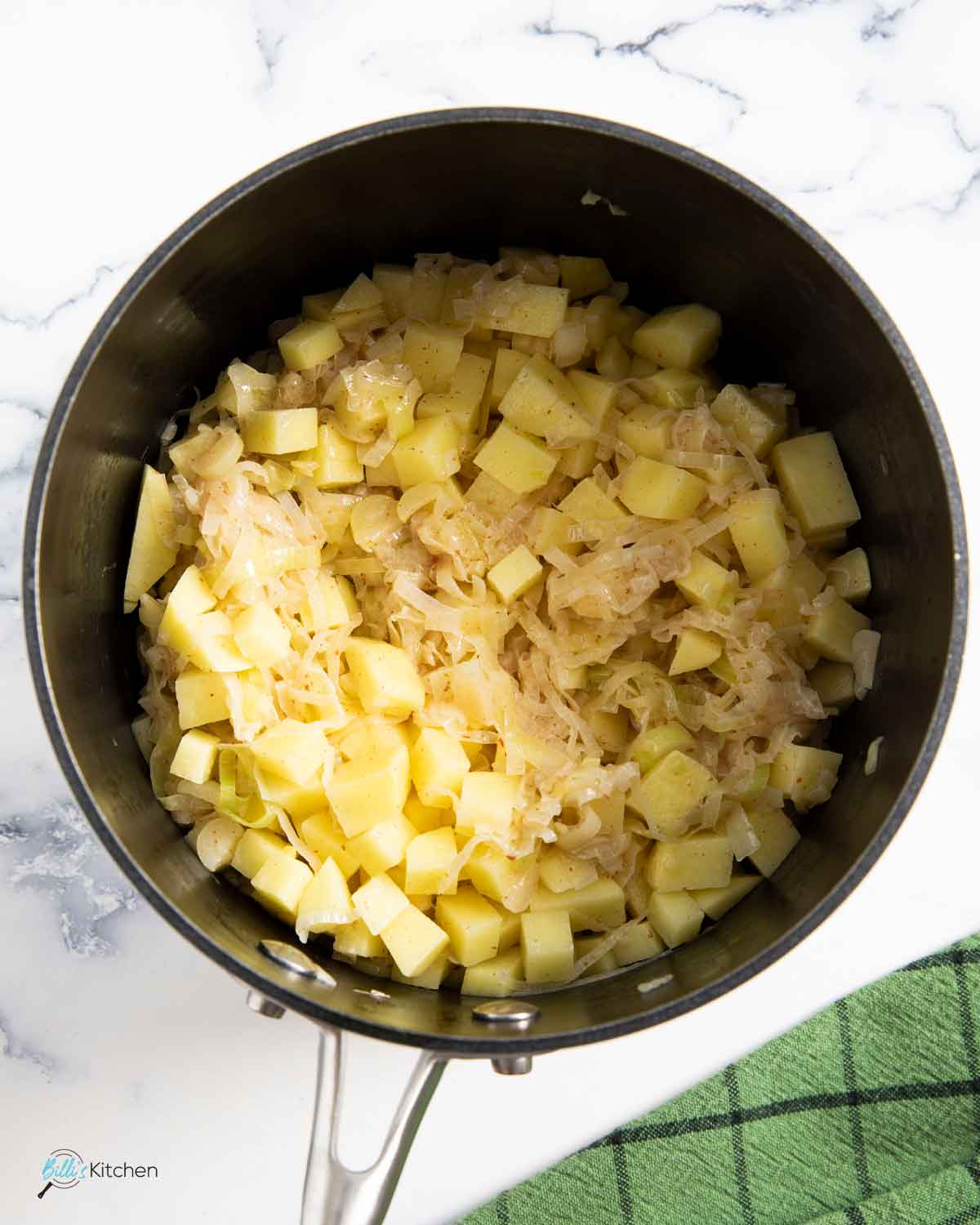 Adding potatoes cut into small cubes into the softened leeks.